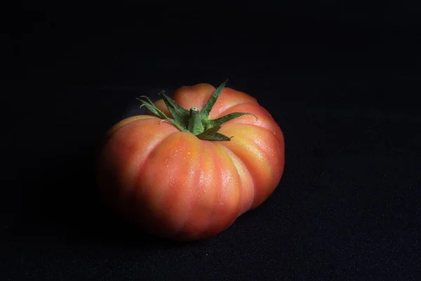 Tiro Close Suculento Tomate Vermelho Uma Superfície Preta — Fotografia de Stock