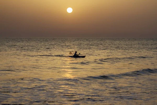 Een Visser Die Vist Golvende Oceaan Onder Stralende Gele Zonsondergang — Stockfoto