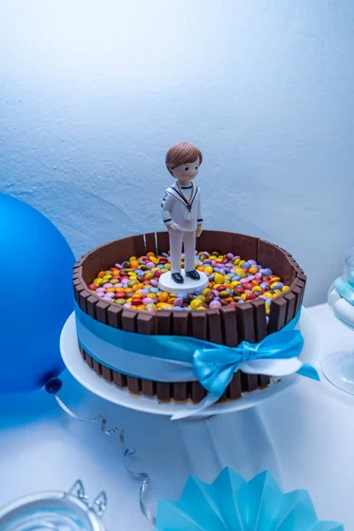 キャンディー入りのチョコレートの誕生日ケーキと上の水夫の人形 — ストック写真