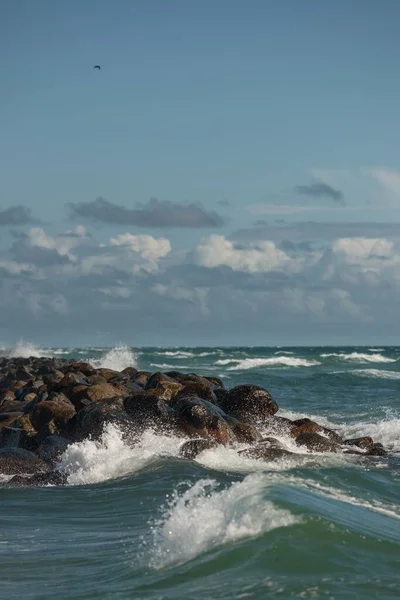在乌云密布的天空下 一片片汹涌的大海 其中有岩石 — 图库照片