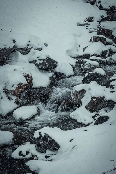 Tiro Vertical Água Que Flui Através Das Pedras Cobertas Neve — Fotografia de Stock