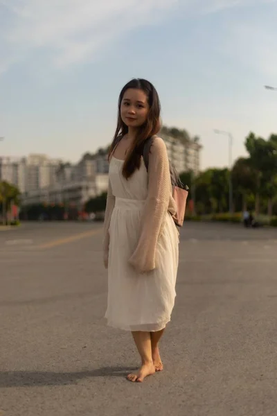 Beyaz Elbiseli Sokakta Çıplak Ayakla Poz Veren Asyalı Bir Kadının — Stok fotoğraf