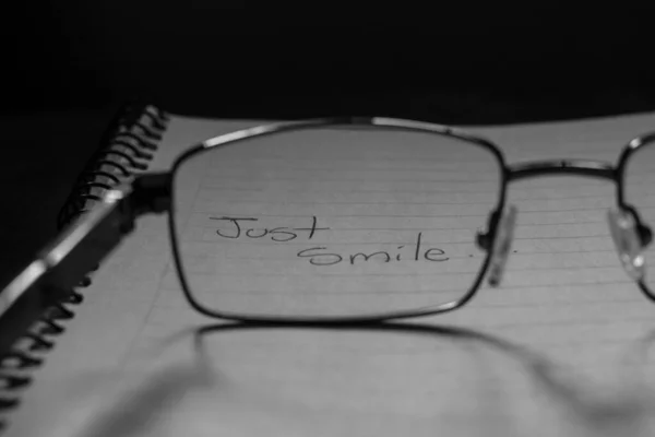 Greyscale Closeup Shot Eyeglasses Notebook Text Just Smile Ditulis Atasnya — Stok Foto