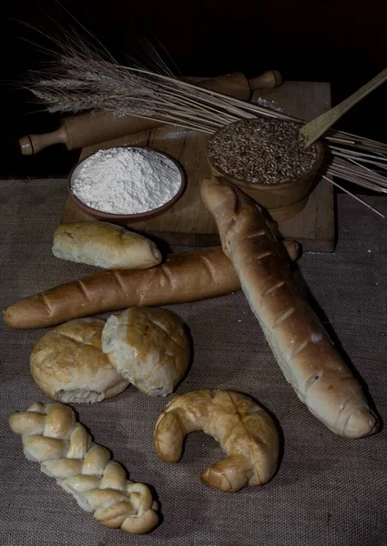 Vertikální Záběr Různých Druhů Chleba Stole Moukou Pšenicí Miskách Pod — Stock fotografie