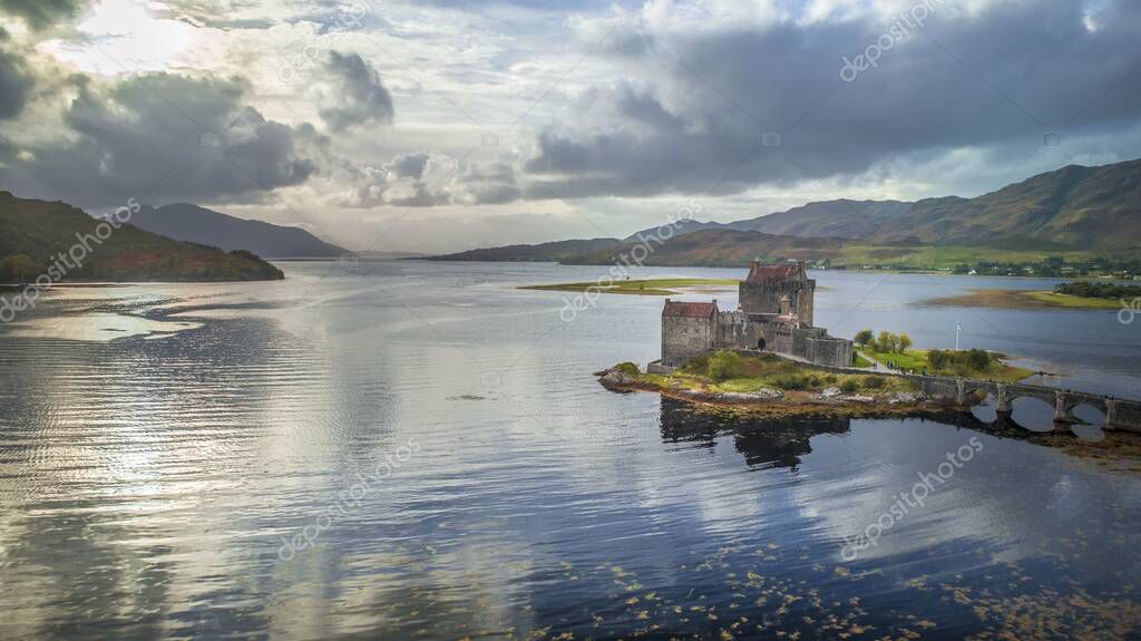 Beautiful Scottish castle  during a sunny afternoon in Scotland taken along the green and yellow banks of Loch Duich with mountain view background