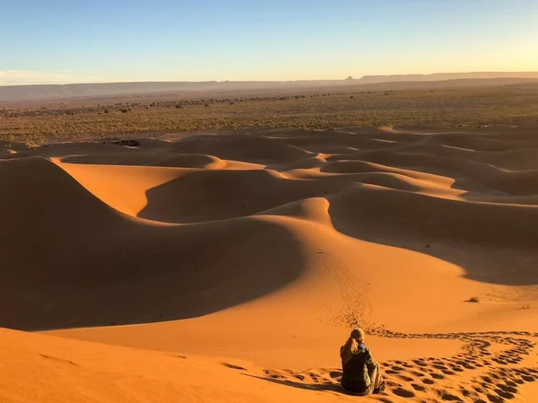 Een Man Zittend Een Duin Een Woestijn Omringd Door Sporen — Stockfoto