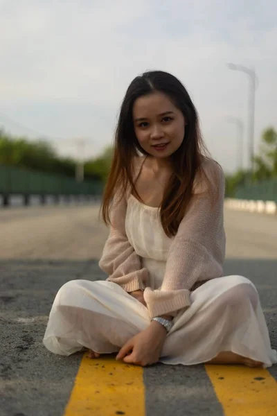 横断歩道に座っている若いアジアの女性の垂直ショット — ストック写真