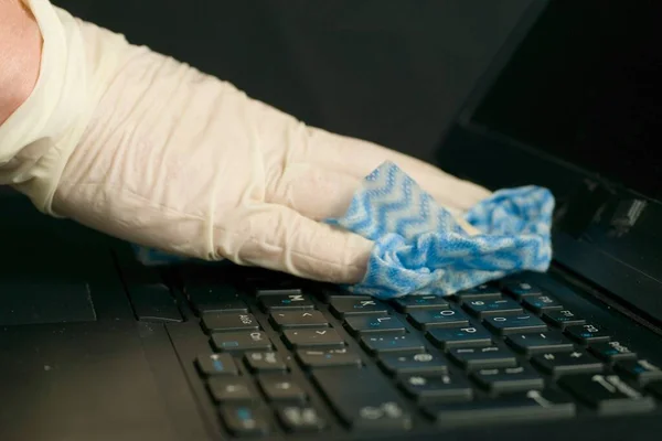 Die Hände einer Person mit Handschuhen reinigen den Laptop zur Vorbeugung gegen Coronavirus-Bakterien — Stockbild Die Hände Einer Person Mit Handschuhen Reinigen Den Laptop Zur — Stockfoto