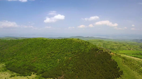 Een Landschap Van Heuvels Bedekt Met Groen Onder Het Zonlicht — Stockfoto