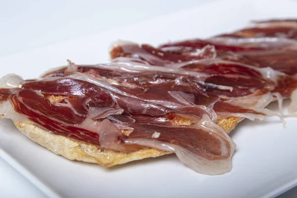 Heerlijke Spaanse Serrano Ham Het Knapperige Brood Een Witte Tafel — Stockfoto