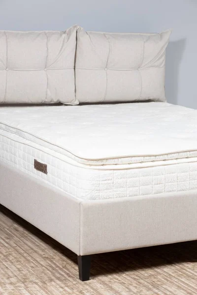 Bej Kumaşlı Beyaz Şilteli Yastıklı Bir Yatağın Dikey Görüntüsü — Stok fotoğraf