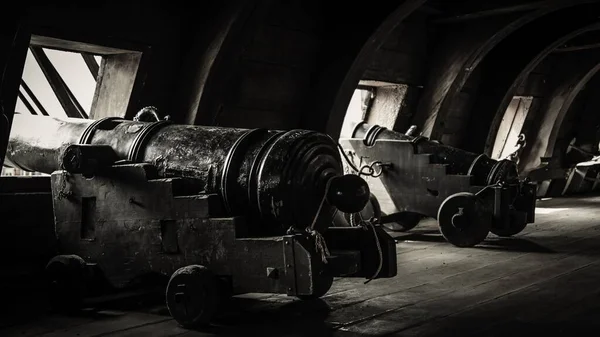 A grey scale shot of a ship\'s gun port from the inside