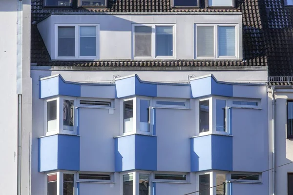 Ein Hellblaues Wohnhaus Mit Dreieckigen Fenstern Und Balkonen — Stockfoto