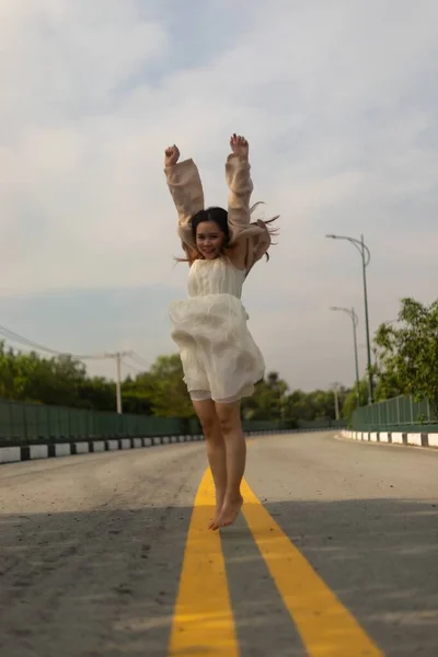 Sokakta Zıplayan Asyalı Bir Kadının Dikey Görüntüsü — Stok fotoğraf