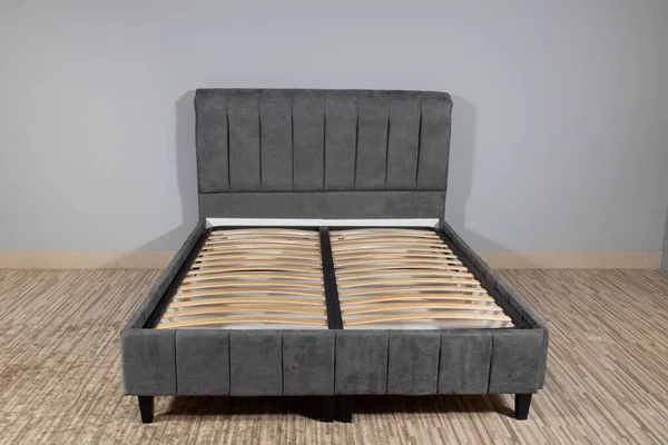 Ein Bett Mit Grauen Stoffpolstern Und Einem Holzgestell Ohne Matratze — Stockfoto