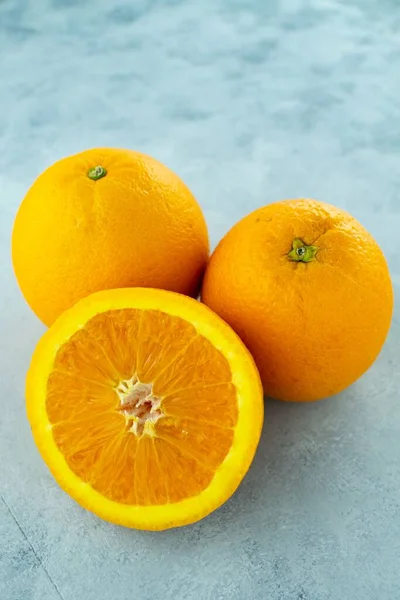 Pionowe Zbliżenie Świeżych Dojrzałych Pomarańczy Jasnoniebieskim Tle — Zdjęcie stockowe