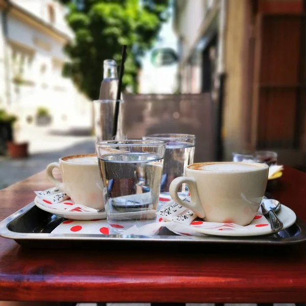 Nahaufnahme Eines Metalltabletts Mit Kaffeetassen Und Wassergläsern — Stockfoto