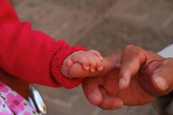 Yaşlı Bir Adamın Parmağını Tutan Sevimli Bir Bebek — Stok fotoğraf