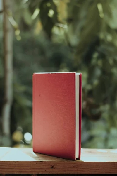 Tiro Vertical Livro Com Uma Tampa Vermelha Uma Cerca Madeira — Fotografia de Stock