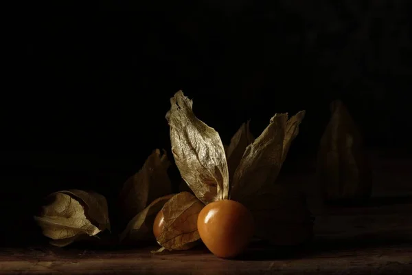 Κοντινό Πλάνο Ώριμων Χρυσοκέρασων Ξερά Φύλλα Στο Τραπέζι Σκούρο Φόντο — Φωτογραφία Αρχείου
