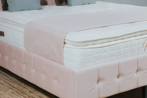Pembe Kumaş Döşemeli Beyaz Şilteli Battaniyeli Yastıklı Bir Yatağın Yakın — Stok fotoğraf