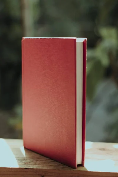Tiro Vertical Livro Com Uma Tampa Vermelha Uma Cerca Madeira — Fotografia de Stock