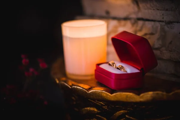 Egy Vízszintes Jegygyűrű Egy Gyönyörű Piros Dobozban Egy Gyertya Mellett — Stock Fotó