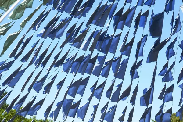 蓝色的旗帜挂在街上的绳子上 映衬着蓝色的天空 — 图库照片