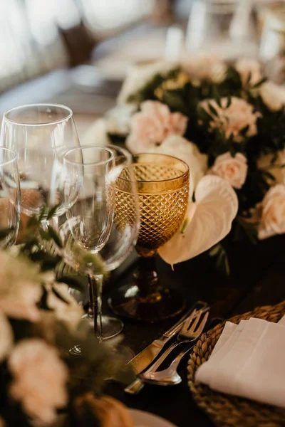 婚宴桌上挂着花卉装饰的酒杯的垂直照片 — 图库照片