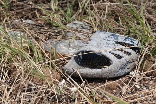 乾燥した汚れた草原で汚れたサンダルのクローズアップショット — ストック写真