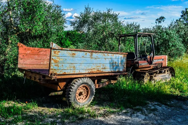 Piękne Ujęcie Starego Ciągnika Przyczepy Zaparkowanych Pobliżu Krzaka — Zdjęcie stockowe