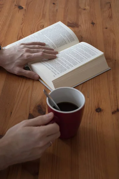 Vertikal Bild Manlig Hand Som Håller Kopp Kaffe Medan Läser — Stockfoto