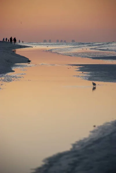 黄金の時間の間にビーチの息をのむような景色ピンクの色合いは水に反映されます — ストック写真