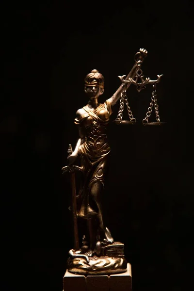 黒の背景に孤立した女性の正義のブロンズ像の垂直ショット — ストック写真