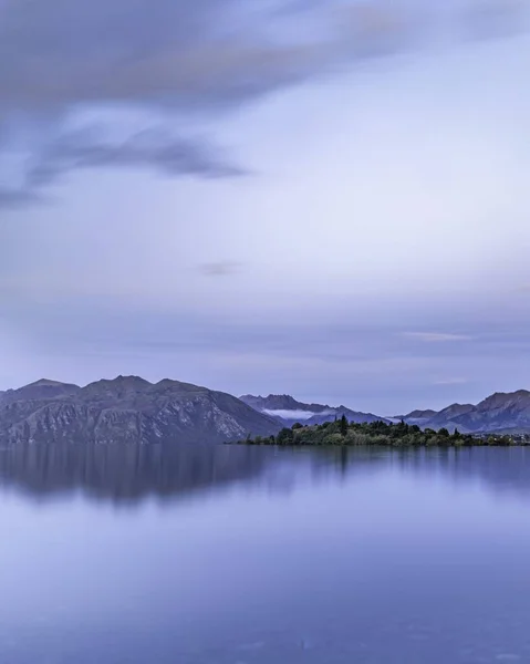 Sebuah Gambar Vertikal Dari Danau Reflektif Yang Tenang Latar Belakang — Stok Foto