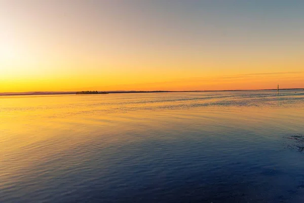 Ett Hisnande Landskap Solnedgången Himlen Reflekterar Det Fridfulla Havet — Stockfoto