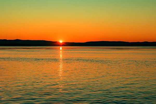 Eine Atemberaubende Szenerie Des Sonnenuntergangs Die Sich Friedlichen Meer Widerspiegelt — Stockfoto