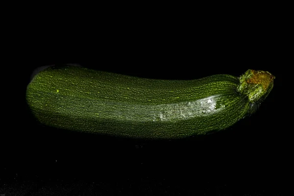黒の背景に隔離された新鮮な緑のズッキーニのクローズアップショット — ストック写真