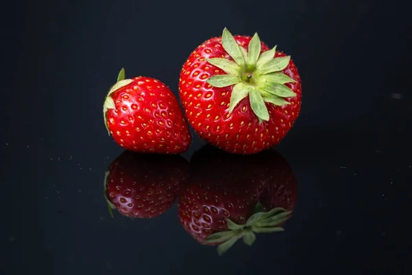 Horizontal Shot Two Red Croatian Strawberries Black Reflecting Surface — Stock Photo, Image