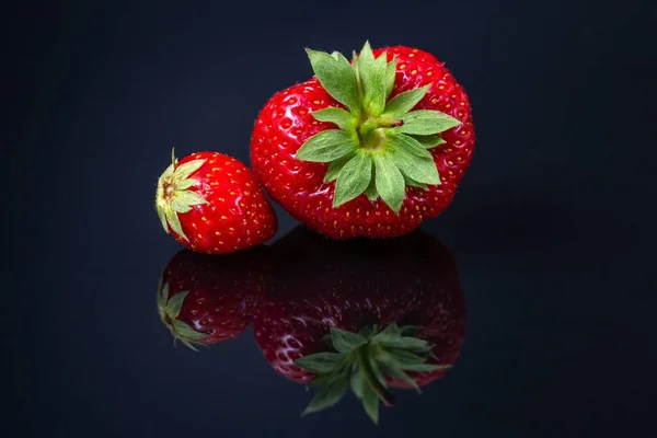 Horizontale Aufnahme Zweier Roter Kroatischer Erdbeeren Auf Einer Schwarz Reflektierenden — Stockfoto