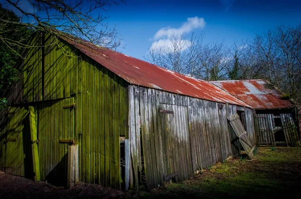 一个破旧的木制谷仓 门破了 屋顶上有波纹铁皮 — 图库照片