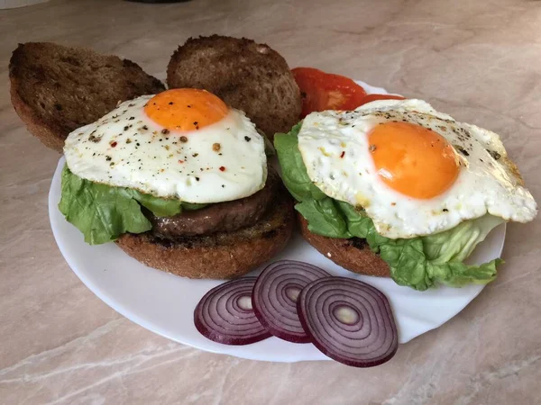 Крупный План Бургера Мясом Яйцами Тарелке Овощами Огнями — стоковое фото