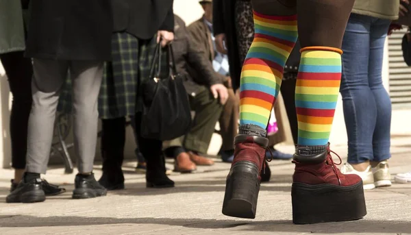 A closeup shot of platform shoes with LGBT socks on the street