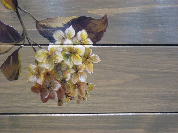 A closeup shot of a beautiful tree branch decoupage with flowers on a wooden furniture