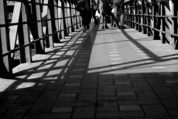 Серый Снимок Людей Идущих Мосту Днем — стоковое фото