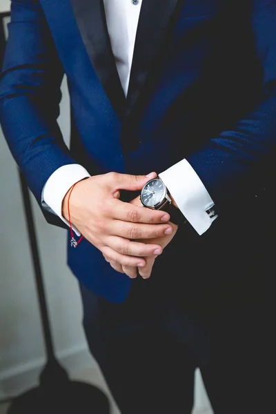 男性穿着蓝色西服和手持手表的垂直照片 — 图库照片