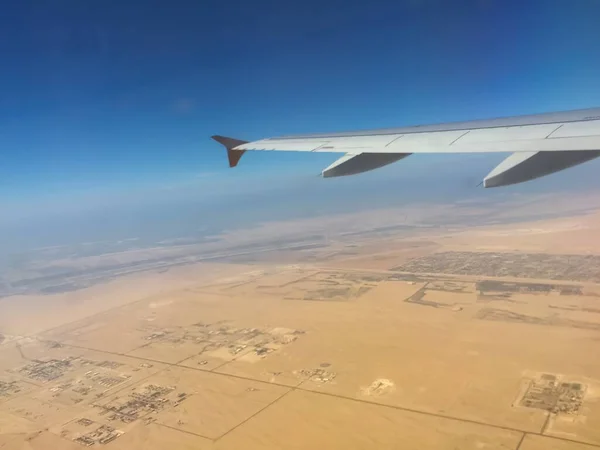 空を飛ぶ飛行機の窓から見た砂漠 — ストック写真