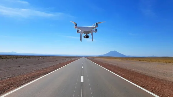 A closeup of a drone flying over the street against a beautiful sky