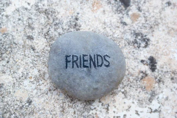 岩の地面に灰色の小石に書かれた友達という言葉 — ストック写真