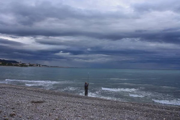 Una Hermosa Foto Pescador Una Playa Sobre Fondo Nublado Del — Foto de Stock